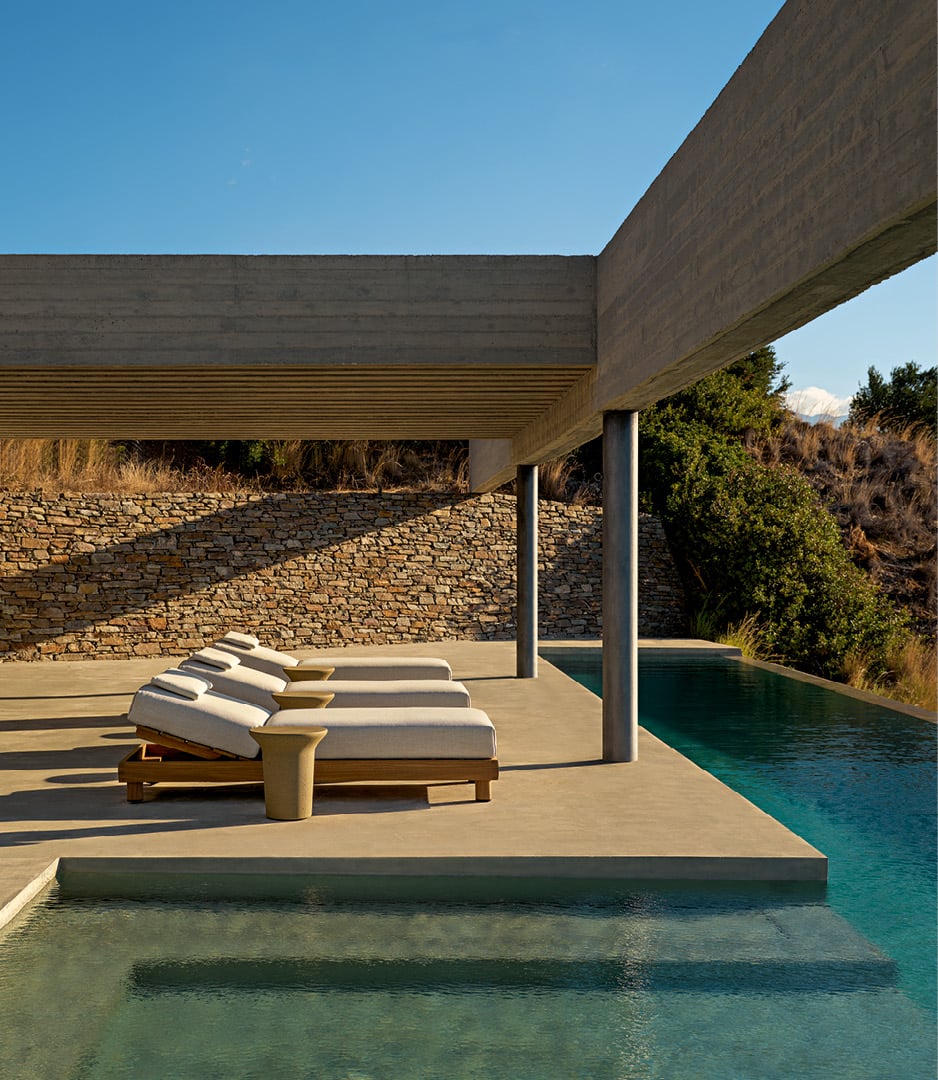 Ambiente exterior en una villa moderna, zona de piscina con tumbonas Ketch, mesa auxiliar Reef en Cementoraw® menta.