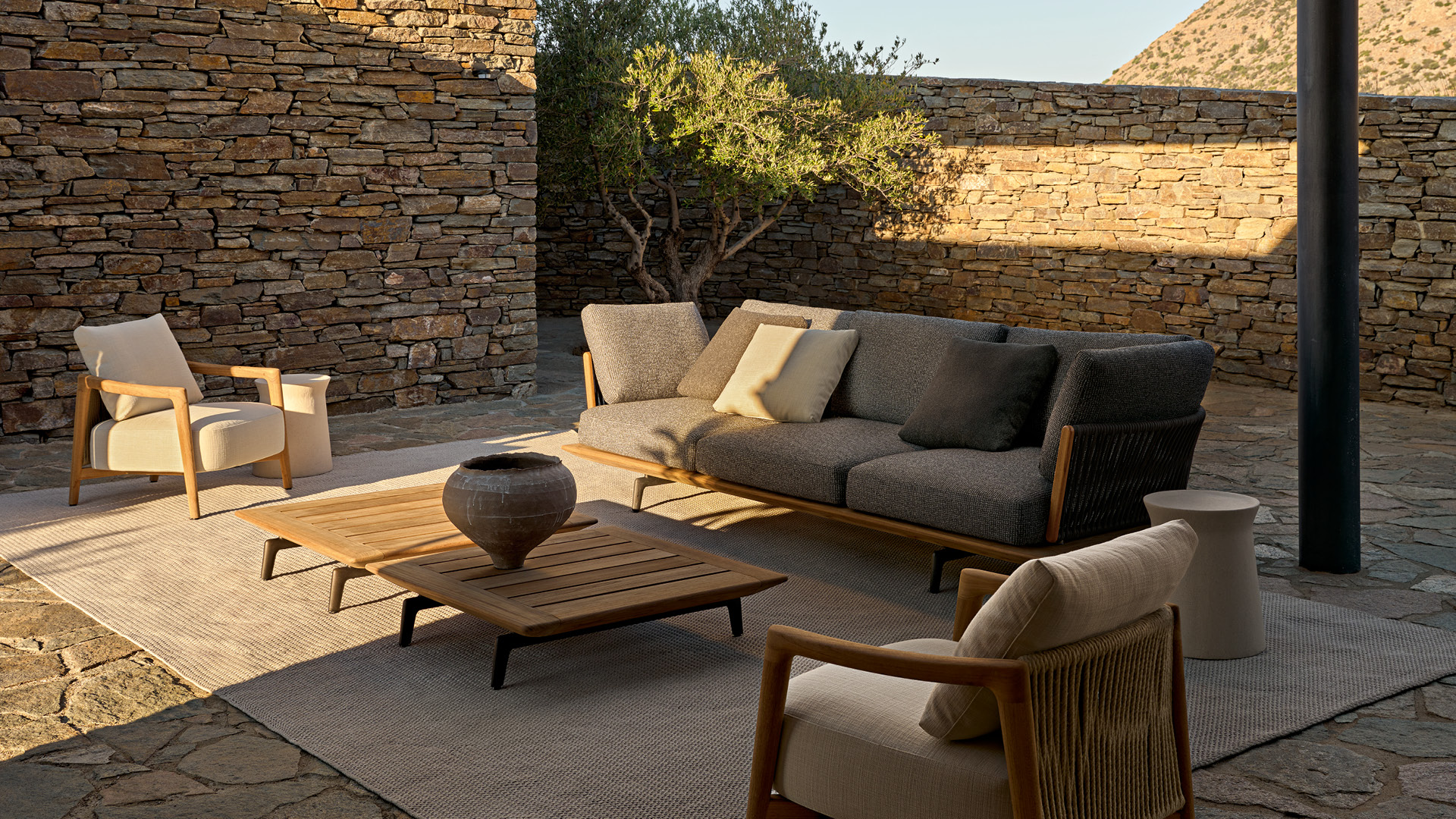 Ambiente outdoor moderno con divano Lagoon e poltrona Ponte e tavolini Lagoon.