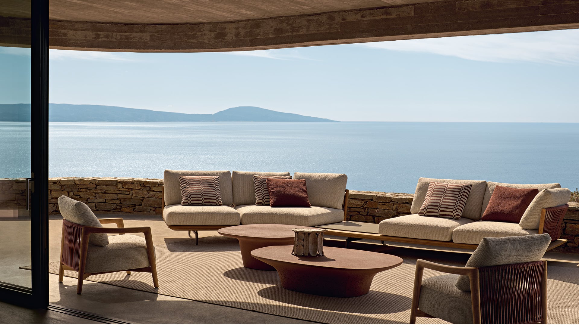 Moderne Outdoor-Umgebung mit Lagoon-Sofa, Ponte-Sessel und Reef-Couchtischen.