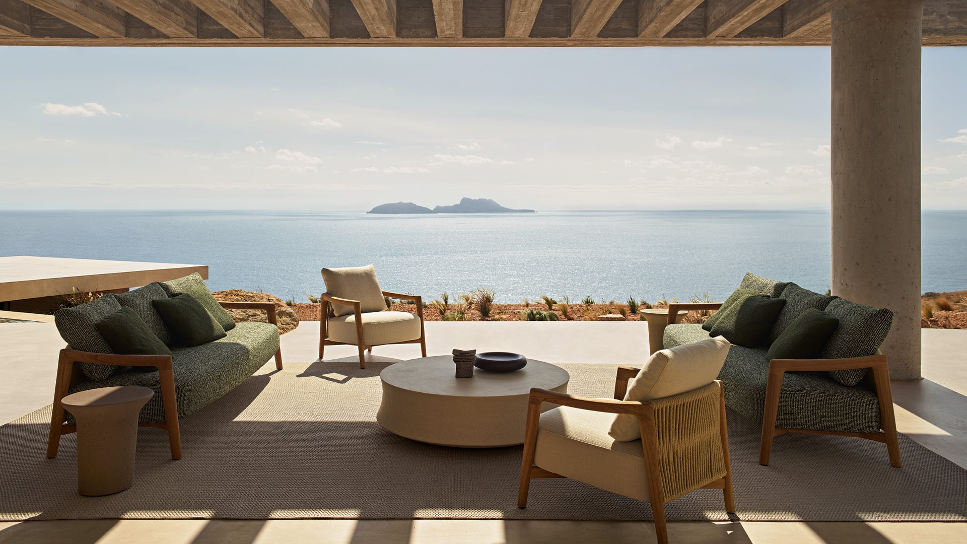 Ambiente outdoor moderno con divano Ponte, poltrona Ponte, tavolini Reef e Soori.