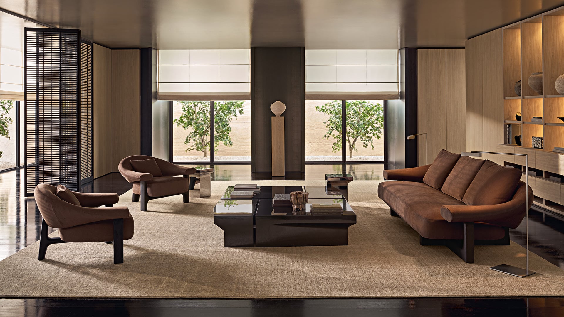 Modern living room with Owen leather sofa and armchair, Joan coffee tables, wall system and wooden bookcase.