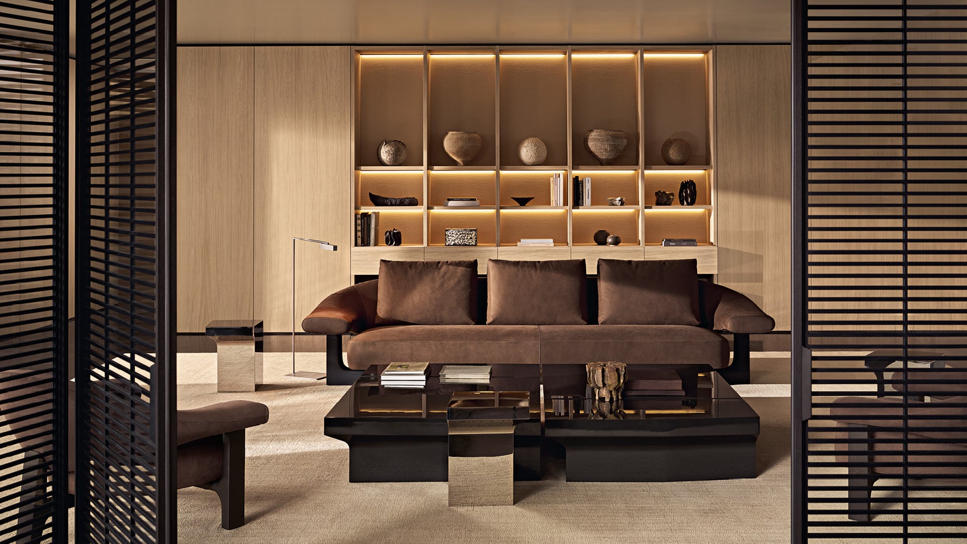 Modern living room with Owen leather sofa and armchair, Joan coffee tables, wall system and wooden bookcase.